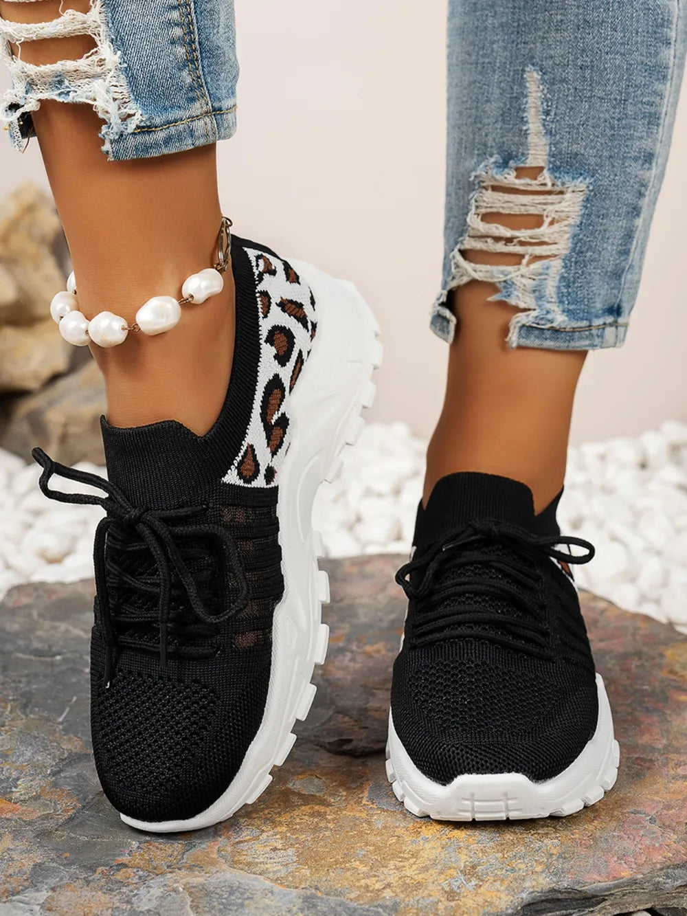 Front-on view of black leopard mesh shoe showing toe knit