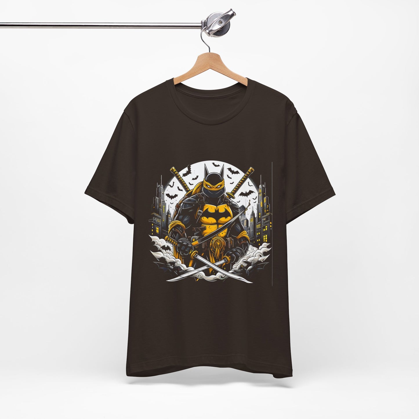 Brown variant front view of Ninja Batman tee on hanger — centered full graphic with yellow highlights