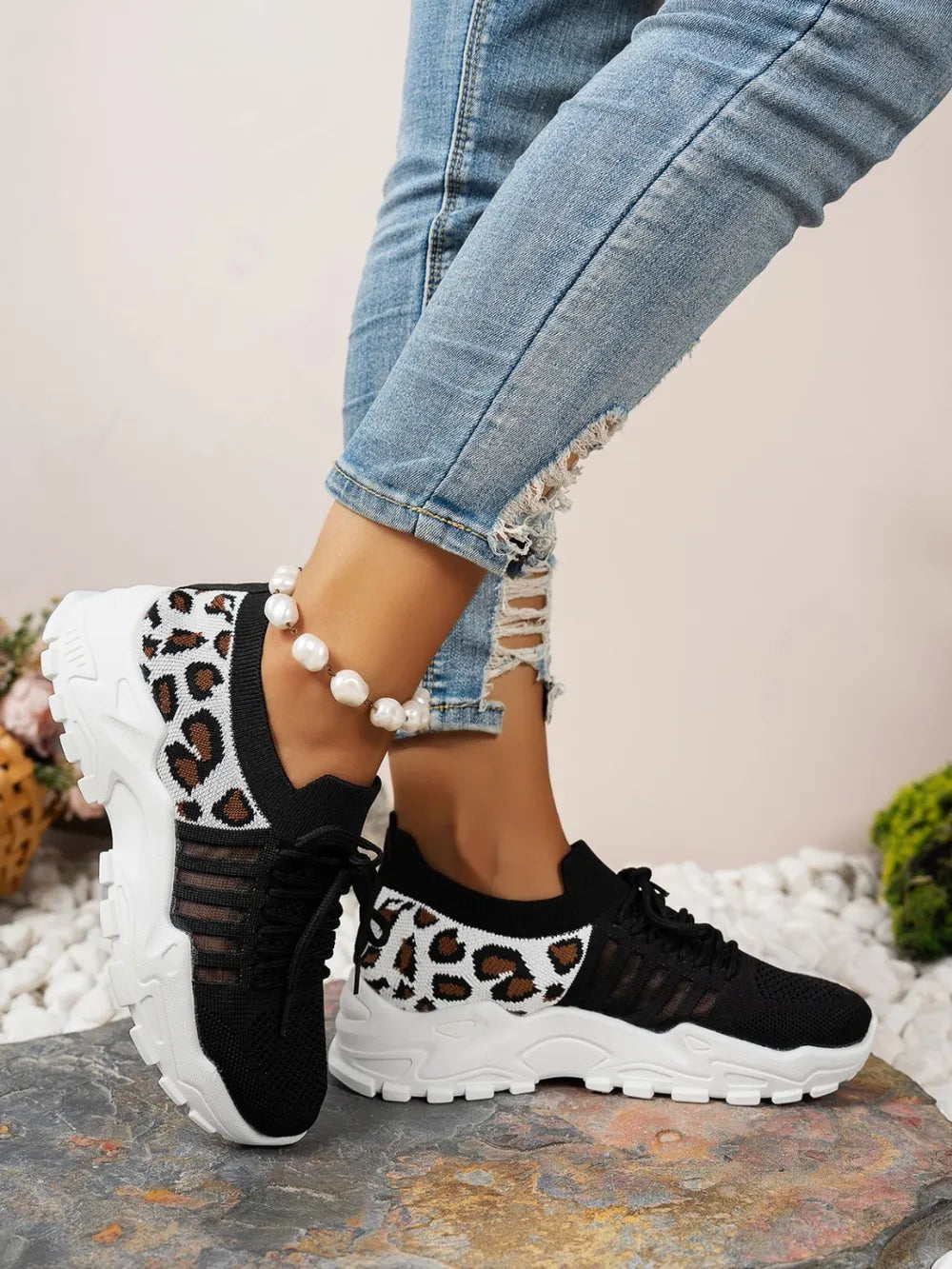 Model wearing black leopard mesh athletic shoe - side view